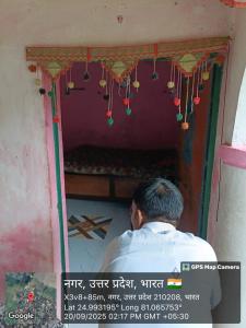 een man die voor een kamer met lichten zit bij Kuldeep Mishra Rural Homestay in Karwi