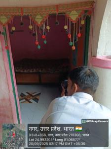 een man die een foto neemt van een kamer bij Kuldeep Mishra Rural Homestay in Karwi