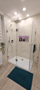 y baño con cabina de ducha y alfombra verde. en Seenland Getaway - Haus am Berg, en Pleinfeld