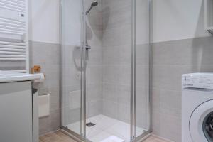 a shower with a glass door in a bathroom at Le Coq Franciosy - AC - WiFi - New - Sea in Menton