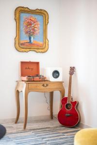 a room with a table with a guitar and a mirror at Le COQ Grace Kelly - Parking - AC - Amazing view in Roquebrune-Cap-Martin