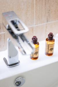 zwei Flaschen ätherischer Öle auf einem Waschbecken in der Unterkunft Le COQ Grace Kelly - Parking - AC - Amazing view in Roquebrune-Cap-Martin