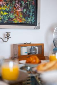 einen Tisch mit einem Teller Essen und einem Gemälde in der Unterkunft Le COQ Grace Kelly - Parking - AC - Amazing view in Roquebrune-Cap-Martin + 26 Fotos