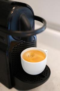 a cup of coffee sitting on top of a microwave at Le COQ Grace Kelly - Parking - AC - Amazing view in Roquebrune-Cap-Martin