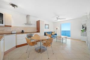 a kitchen and living room with a table and chairs at Le COQ Gabriel - Parking - Amazing view in Roquebrune-Cap-Martin +23 photos