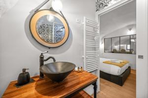 een badkamer met een wastafel en een spiegel op een tafel bij Le COQ Grimaldi - AC - WiFi in Roquebrune-Cap-Martin