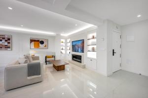 a white living room with a couch and a tv at Picasso 2 Royal in Marbella