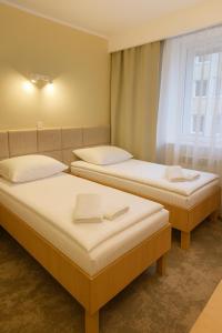 ラドムにあるHotel Kameralny TMの窓のある部屋にツインベッドが2台