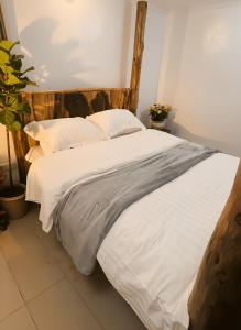 a large white bed with white sheets and pillows at Chris's at the Park in Nairobi