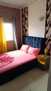 a bedroom with a bed with red sheets and a window at Wharf , Vue sur l'océan in Pointe-Noire