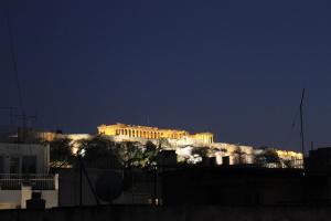 a building on top of a hill at night at Boutique Central Apartments Acropolis View in Athens