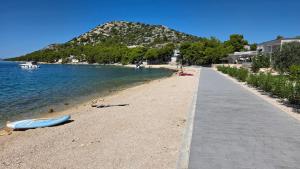 a beach with a blue boat on the shore at Mobile Home Tom 12 in Drage