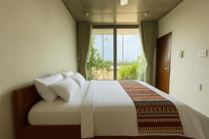 a bedroom with a large bed with a window at Marvelous Homestay Hoi An in Dien Ban