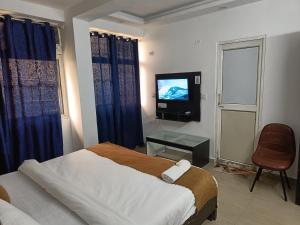 een slaapkamer met een bed en een televisie. bij Hotel Stay Inn in Noida