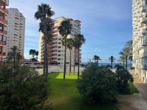 a view of a park with palm trees and buildings at Safestay Calpe Seafront - Apartment Atlantico in Calpe