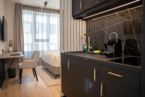 a kitchen with a sink and a bedroom with a bed at The MYDE Hamburg Serviced Apartments in Hamburg +9 photos