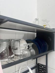 Un estante con jarrones de cristal y platos encima. en Homestay Rancabango A4 Garut, en Tarogong