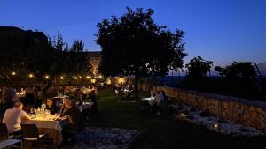 a group of people sitting at tables in a garden at night at Domus Narnia in Narni