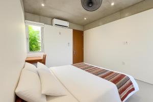 a bedroom with a white bed and a window at Marvelous Homestay Hoi An in Dien Ban