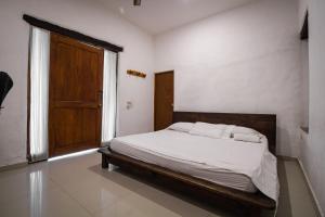 1 dormitorio con 1 cama con marco de madera y puerta en Hotel Jordan, en Guaduas