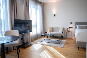 a white living room with a couch and a tv at The MYDE Hamburg Serviced Apartments in Hamburg