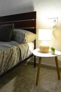 a bed with a table with a lamp on it at Safestay Calpe Seafront - Apartment Atlantico in Calpe