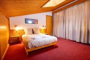 Un dormitorio con una cama y una ventana grande. en Cembros #20 - 4 guests - Ski in - Ski out, en Méribel