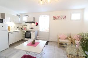 a kitchen with white cabinets and a table in a room at Le Rivage in Sainte-Marie-de-Ré