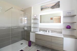 a bathroom with a sink and a shower and a mirror at Le Rivage in Sainte-Marie-de-Ré