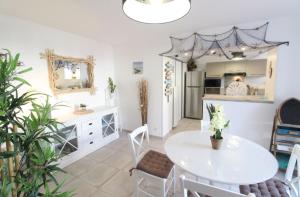 a kitchen and dining room with a white table and chairs at Gite La Paillotte, Ile De Ré in Sainte-Marie-de-Ré