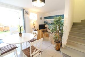 a living room with a table and a table and chairs at Gite La Paillotte, Ile De Ré in Sainte-Marie-de-Ré