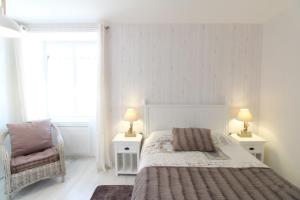 a bedroom with a bed and two lamps and a chair at Gite La Paillotte, Ile De Ré in Sainte-Marie-de-Ré