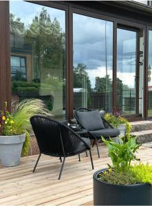 a patio with two chairs and a table and some plants at Hugo Airport in Mārupe