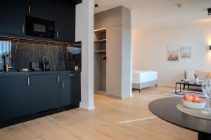 a kitchen with black cabinets and a table in a room at The MYDE Hamburg Serviced Apartments in Hamburg