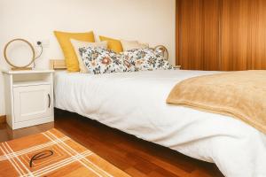 a bedroom with a large white bed with pillows at Casa Vixoi, a 5Km Catedral in Santiago de Compostela