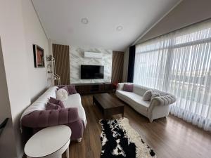 Una sala de estar con un sofá y un televisor. en Mila Villa Foçaköy, en Foca