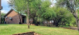a brick house with a tree in the yard at Bloemhof Riverside Chalets 