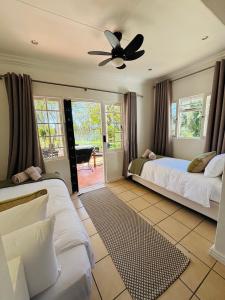 a bedroom with two beds and a ceiling fan at Addo Good Hope Guest House in Sunland