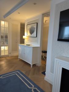 a living room with a white cabinet and a tv at Apartament BIANCO Royal in Częstochowa
