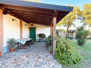 une terrasse en pierre avec une pergola en bois dans l'établissement Casa sul Naviglio, à Calcio