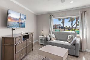 a living room with a couch and a tv at Capri by the Gulf 122 in Destin