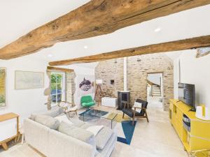 a living room with white walls and wooden beams at Superbe chaumière pour 6 personnes avec jardin in Ploeren