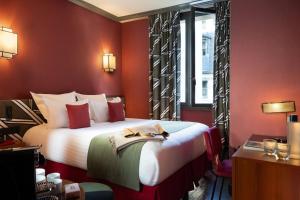 a hotel room with a large bed with red walls at Hôtel Aoriste & Spa in Paris