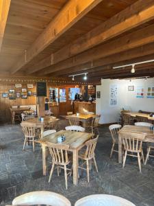 an empty restaurant with wooden tables and chairs at Malhamdale Glamping in Skipton