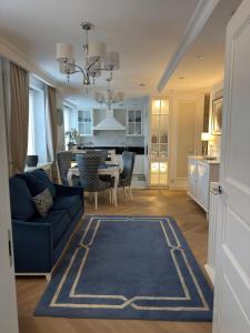 a living room with a blue couch and a table at Apartament BIANCO Royal in Częstochowa