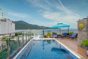una piscina con sombrilla en la parte superior de un edificio en Cani Beach House, en Da Nang