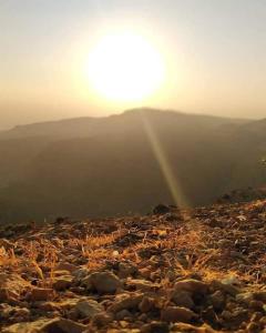 a sun setting on a rocky hill with the sun setting at Camping Guide in Dana