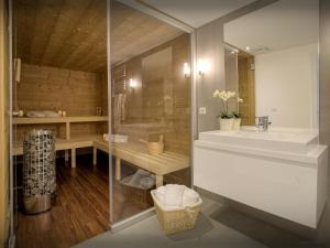 a bathroom with a shower and a sink and a tub at Chalet Le Mousqueton - OVO Network in La Clusaz