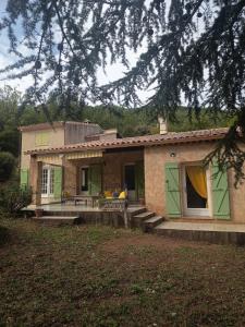 a small house with green doors and a porch at Gîte Léonfine in Le Cannet-des-Maures