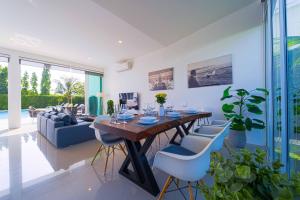 a living room with a wooden table and chairs at Harmony Villa 5 Bedroom Modern Pool Villa - KH-A7 in Khao Tao